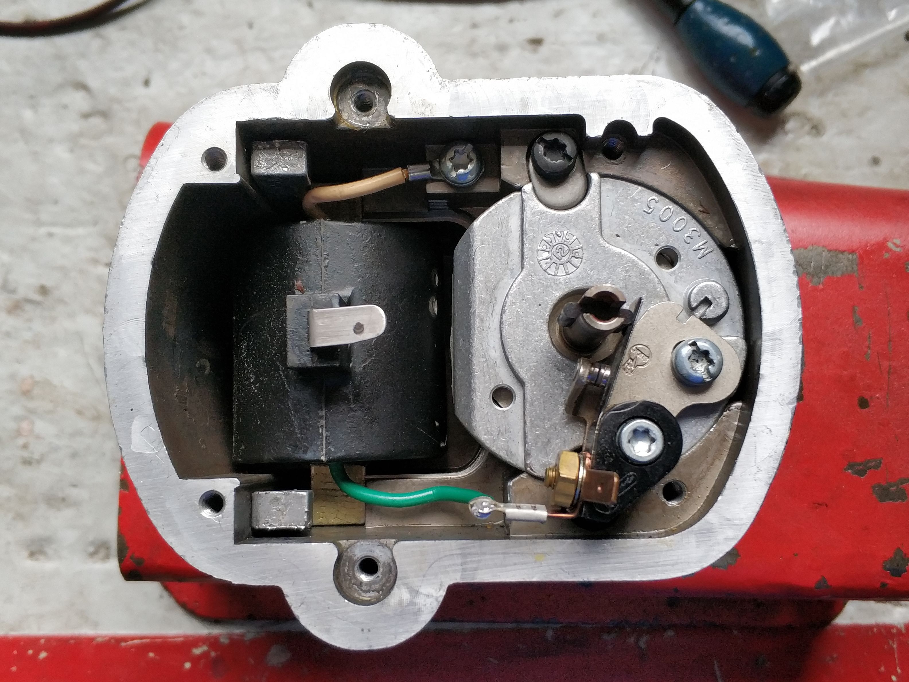 The disassembled magneto; the breaker is on the right and the coil is on the left. The disassembled magneto; the breaker is on the right and the coil is on the left.